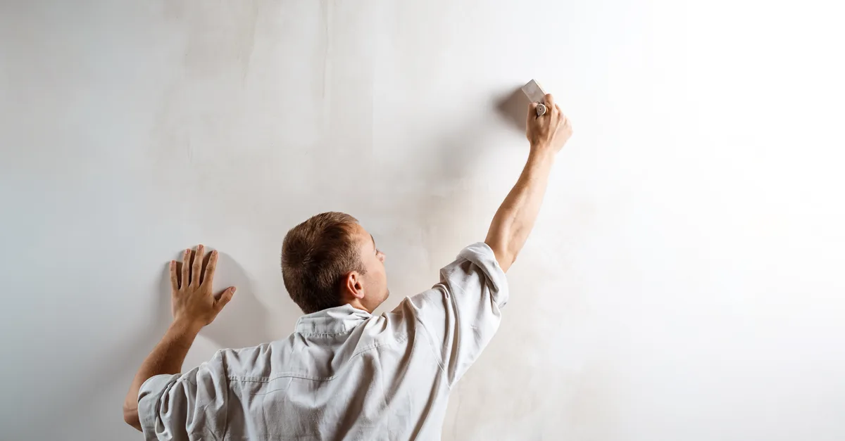 Applying a fresh coat of neutral paint to a wall before selling the house